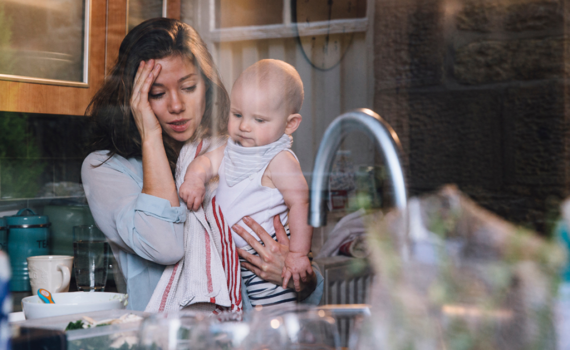 Gestresste Mutter mit Baby im Arm – Symbolbild für Überforderung, Stress und den Einfluss auf Verdauung und Ernährung